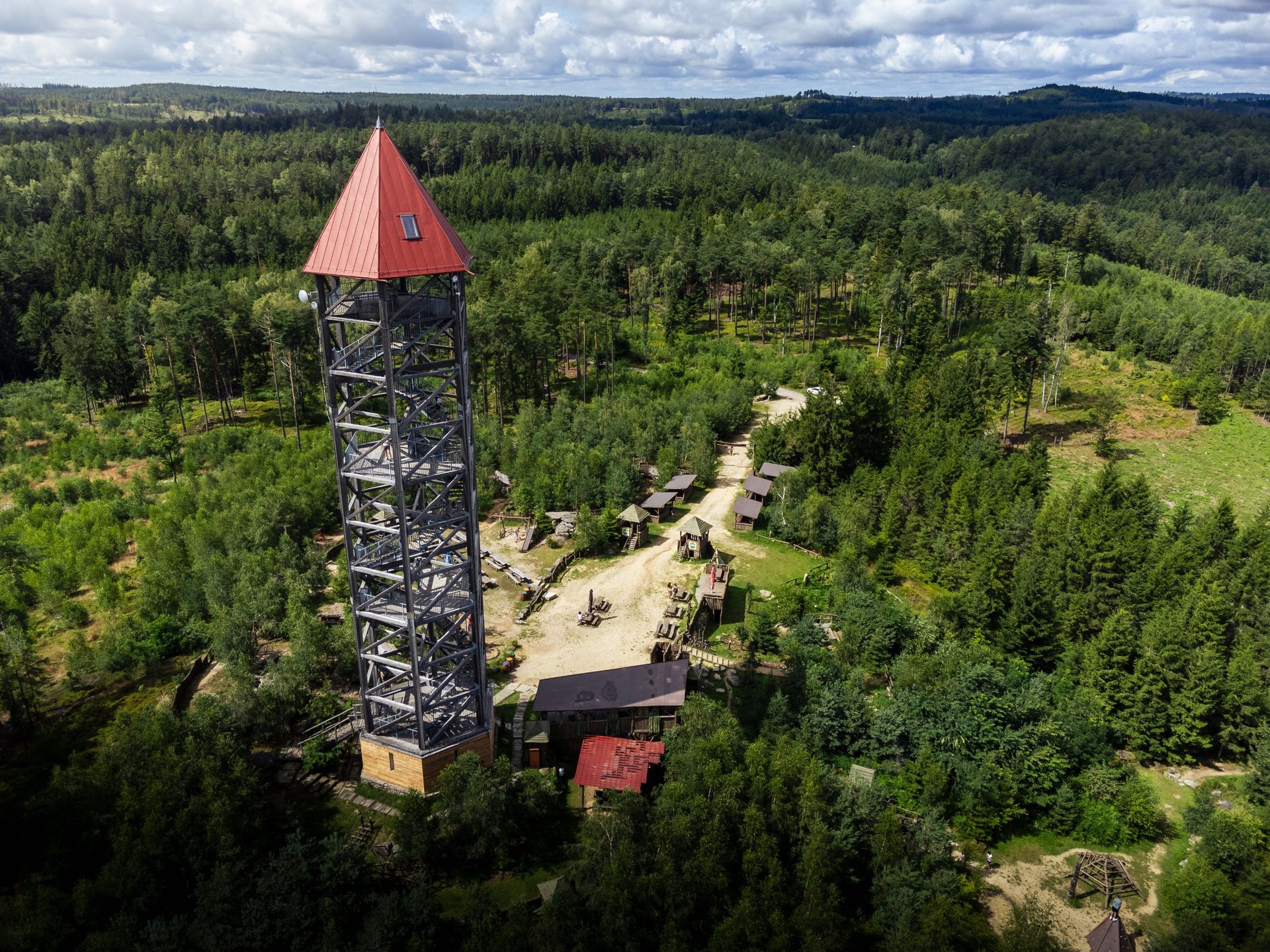 Rozhledna U Jakuba s červenou střechou nad lesy České Kanady